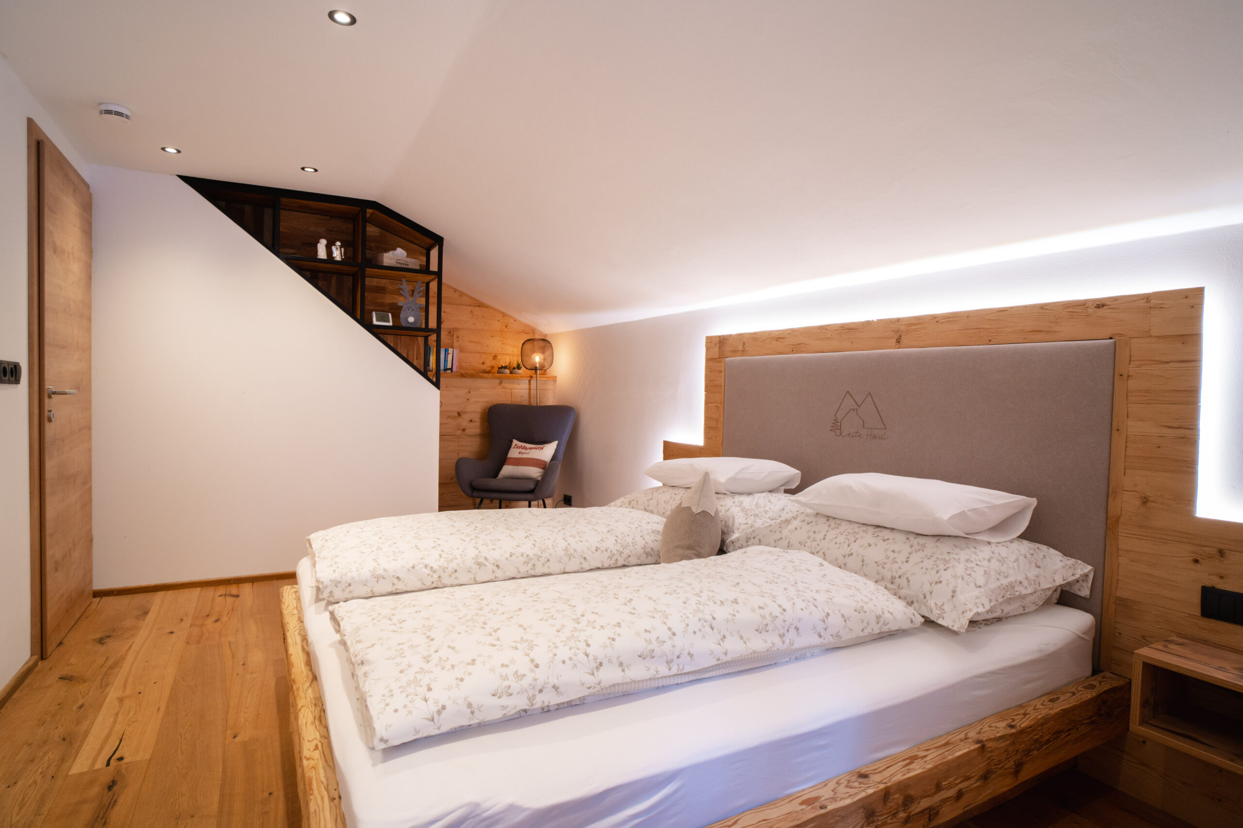 Großes Schlafzimmer mit Leseecke, Schaukelstuhl und indirekter Beleuchtung